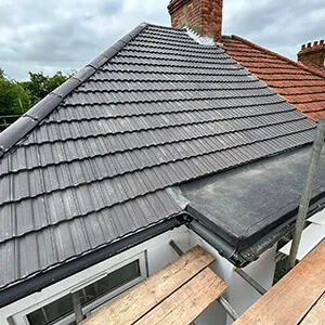 The roof of a house with a wooden bench in front of it.