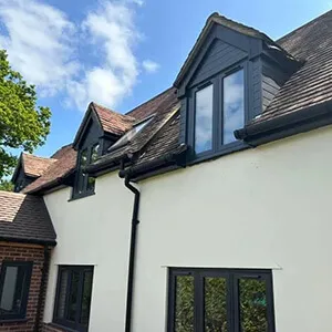 A white house with a black roof and windows.