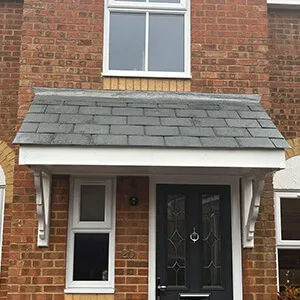 A brick house with a black door and windows.
